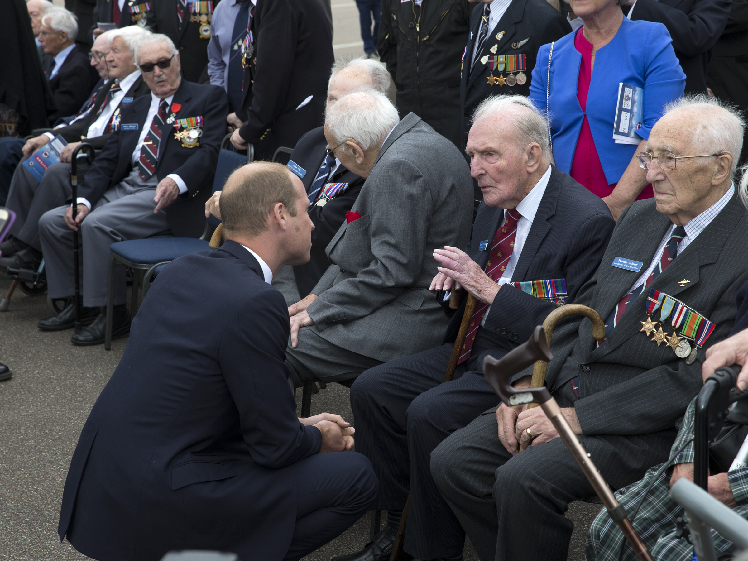 Prince William crouches to speak with Johnny and other Veterans.